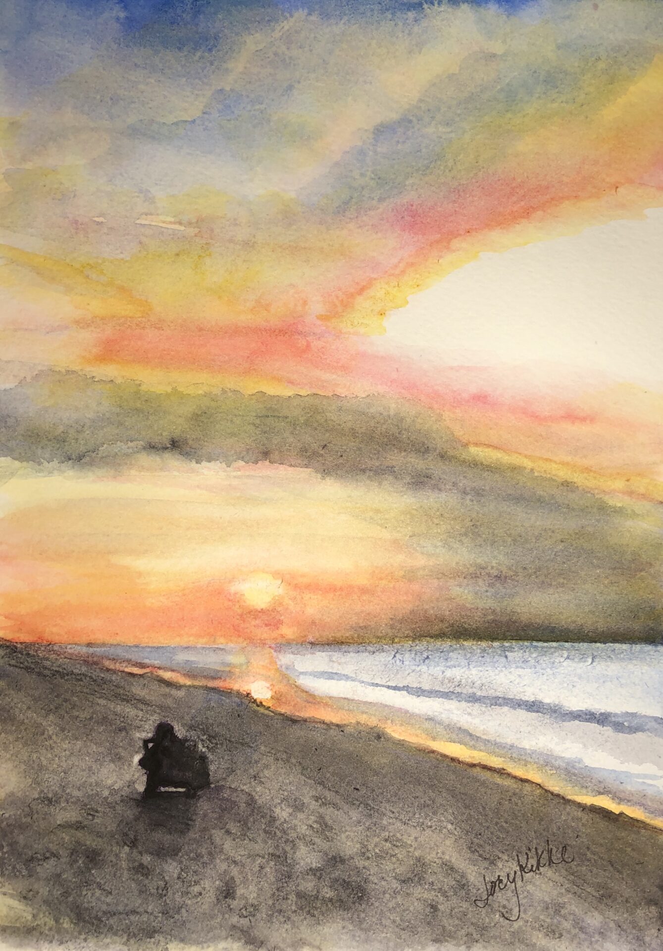 Sunset at the beach with person in a beach chair.