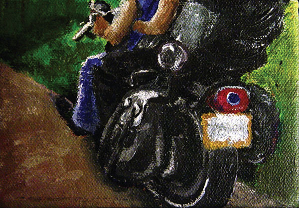 A partial view of a couple of bikers on a dirt road
